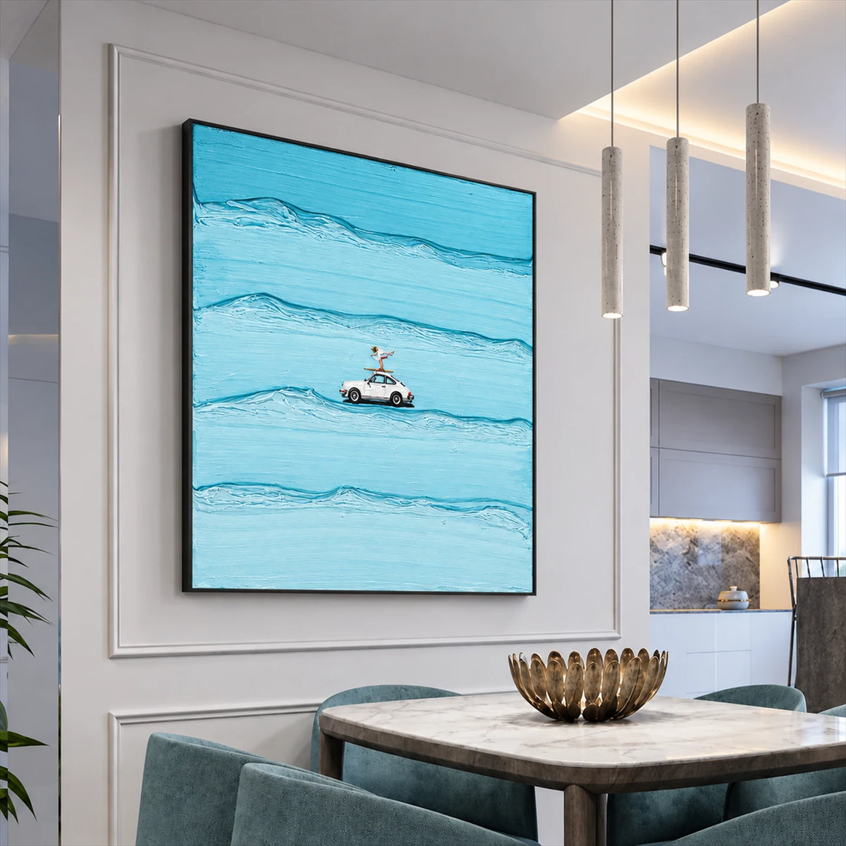 Black-framed blue car and surfer artwork beside a marble dining table and green upholstered chairs.