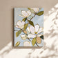 Unframed magnolia canvas on a warm neutral wall with soft sunlight and leaf shadows.