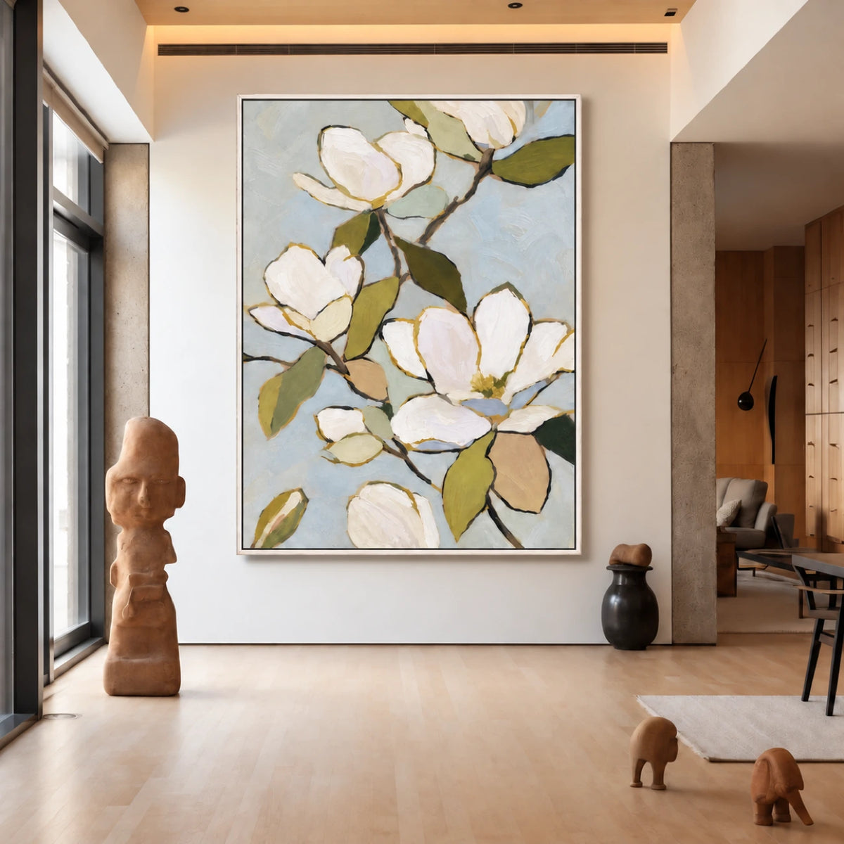 Magnolia painting in a light-colored frame in an airy living space with sculptural decor.