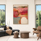 Rose Canyon painting between tall windows in a modern living room with dark seating and round coffee tables.