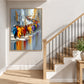 Colorful city procession painting in a light frame beside a wood staircase.