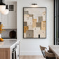 Neutral village painting in a black frame beside a kitchen counter and dining table.