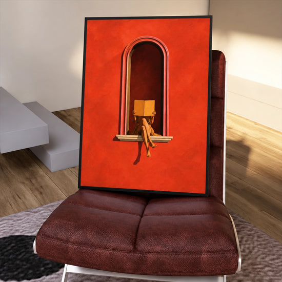 Framed Scarlet Reader painting resting on a burgundy chair in a sunlit interior.
