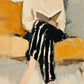 Full artwork of a seated reader holding an open book, wearing a cream blouse and striped black trousers against an ochre and gray background.
