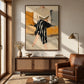 Ochre Reader painting above a wood cabinet beside a brown leather armchair and floor lamp.