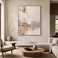 Quiet Earth painting in a light wood-colored frame above a pale sofa and round coffee table.