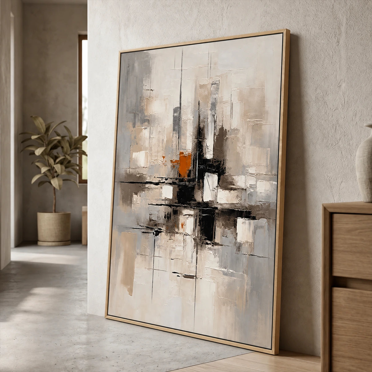 Urban Echo painting in a wood-colored frame leaning against a wall beside a wood cabinet.