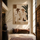 Palm Conversation painting above a leather bench in a sunlit double-height entryway.