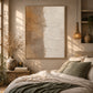Sandstone Lines painting above a bed with earthy linens in a softly lit bedroom.