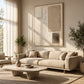 Quiet Forms painting above a pale sofa beside tall curtained windows in a sunlit living room.