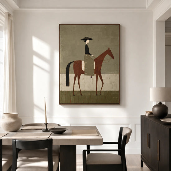 Olive Rider painting above a wood dining table beside a dark sideboard in a bright interior.