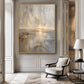 Gilded Horizon painting in a gold frame on a paneled wall beside a cream armchair.