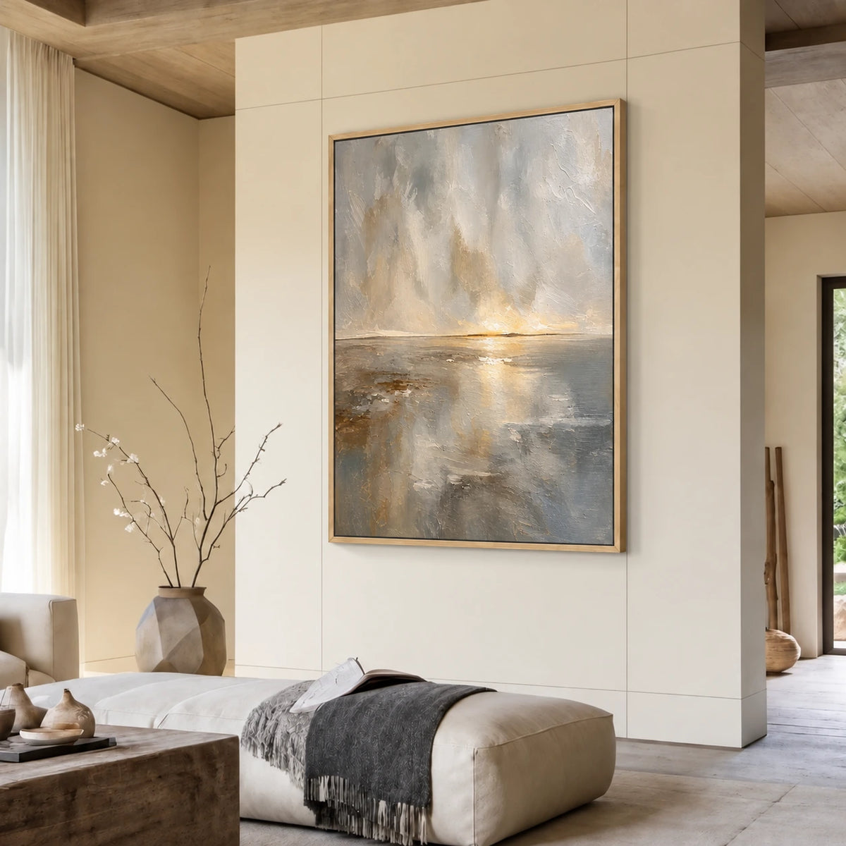 Gilded Horizon painting above a pale ottoman in a warm neutral living room.