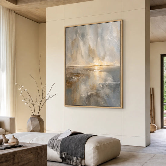 Gilded Horizon painting above a pale ottoman in a warm neutral living room.