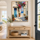 Coastal Passage painting above a light wooden console beside a blue entry door.