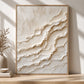 Ivory Tides painting resting on a wooden console beside a vase and stacked books.