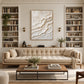 Ivory Tides painting above a tufted beige sofa between built-in bookshelves.