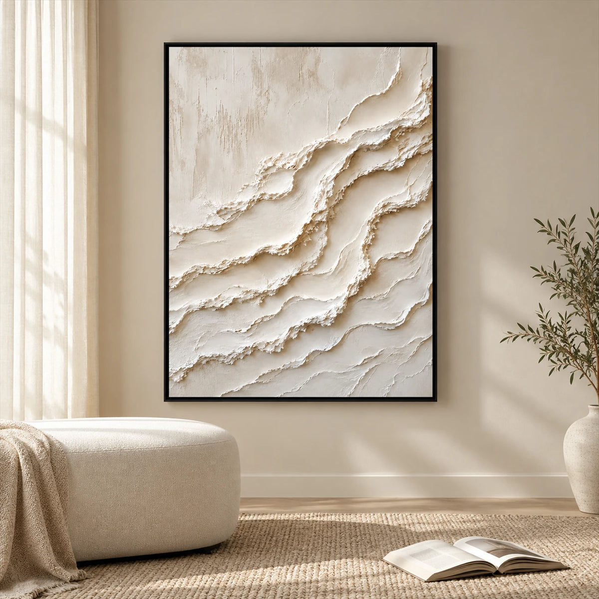 Ivory Tides painting in a black frame beside a cream seat and an open book in a sunlit room.