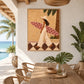 Palmside Surfer painting beside a wooden dining table on a covered terrace overlooking the sea.