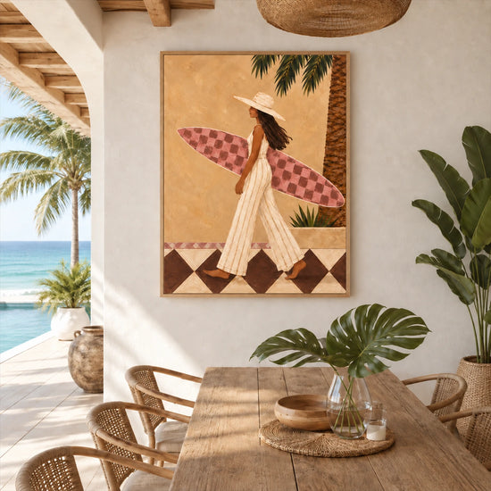Palmside Surfer painting beside a wooden dining table on a covered terrace overlooking the sea.