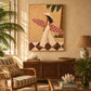 Palmside Surfer painting above a dark wooden cabinet in a room with woven seating and tropical plants.