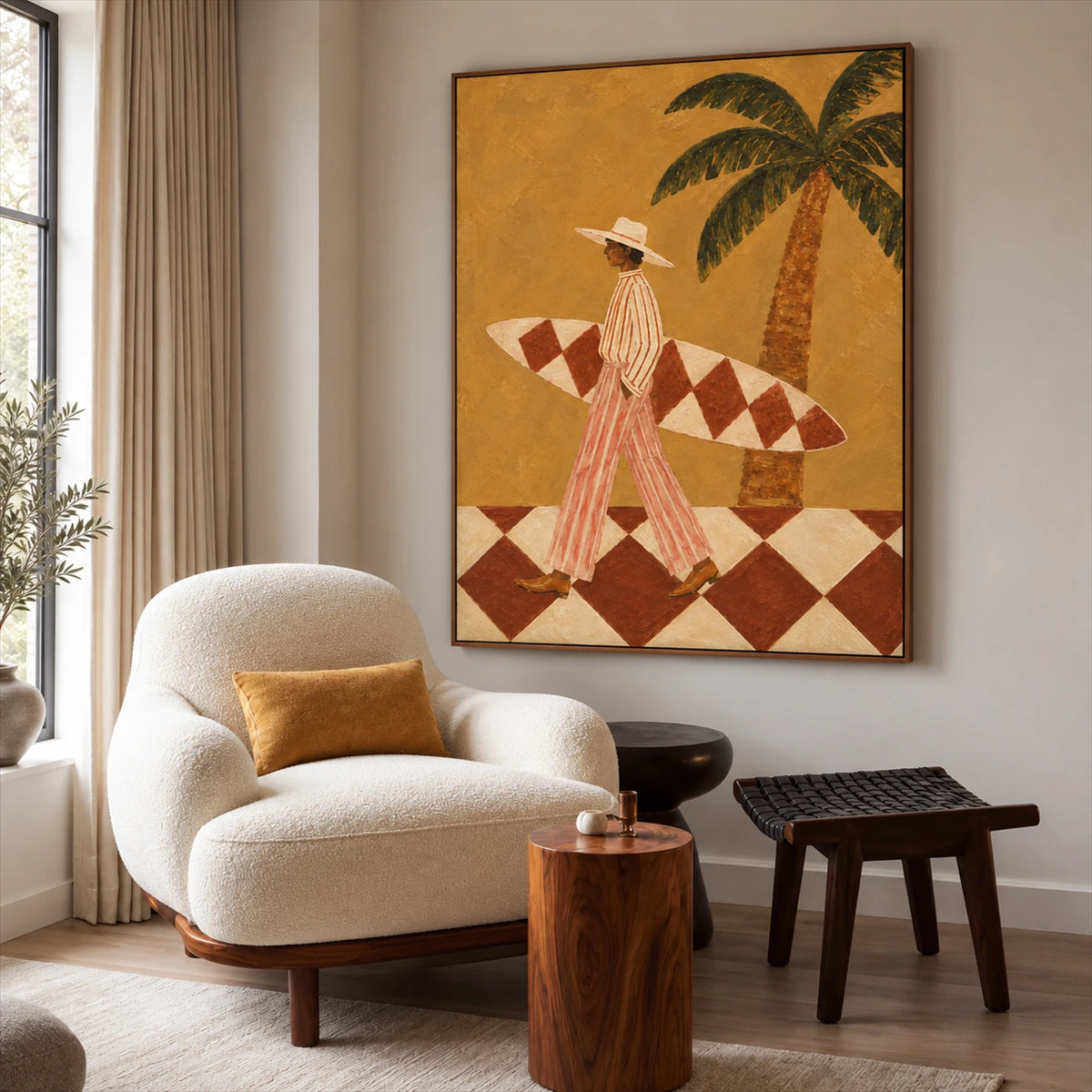 Ochre Surfer painting beside a cream armchair and dark wooden tables near a tall window.