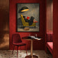 Lamplit Reader painting in a burgundy alcove above a small round table and red upholstered chairs.