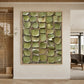 Olive Mosaic painting on a pale wall beside wooden slatted doors in an airy interior.