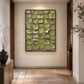 Olive Mosaic painting at the end of a softly lit hallway with a rug and decorative branches.