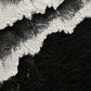 Full abstract artwork of irregular white foam-like bands sweeping diagonally across a deep black field.