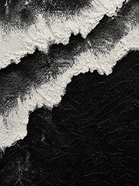 Full abstract artwork of irregular white foam-like bands sweeping diagonally across a deep black field.