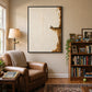 Quiet Perch painting beside a brown leather armchair and filled bookshelves in a cozy reading room.