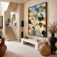 Angled view of Meadow Reverie above a pale console near stairs and oversized ceramic vessels.