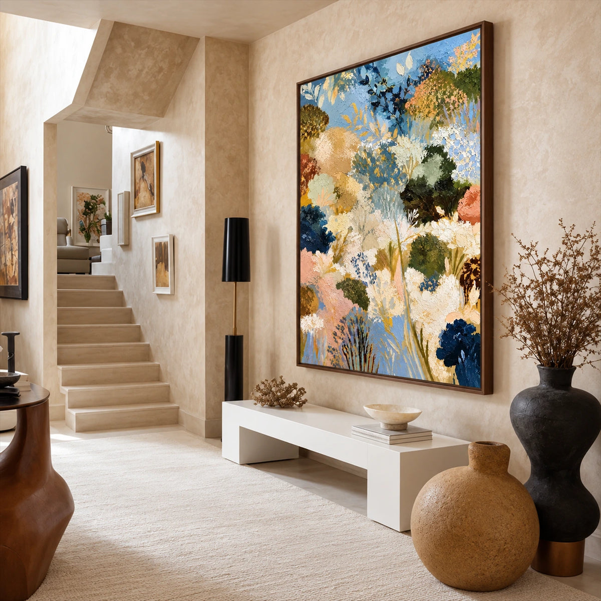 Angled view of Meadow Reverie above a pale console near stairs and oversized ceramic vessels.