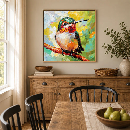 Jewel Hummingbird painting above a rustic wooden sideboard beside a dining table and bright windows.