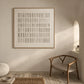 Quiet Grid painting beside a wooden armchair in a softly lit room with woven textures.