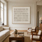 Quiet Grid painting above a wooden coffee table between pale seating in a paneled living room.