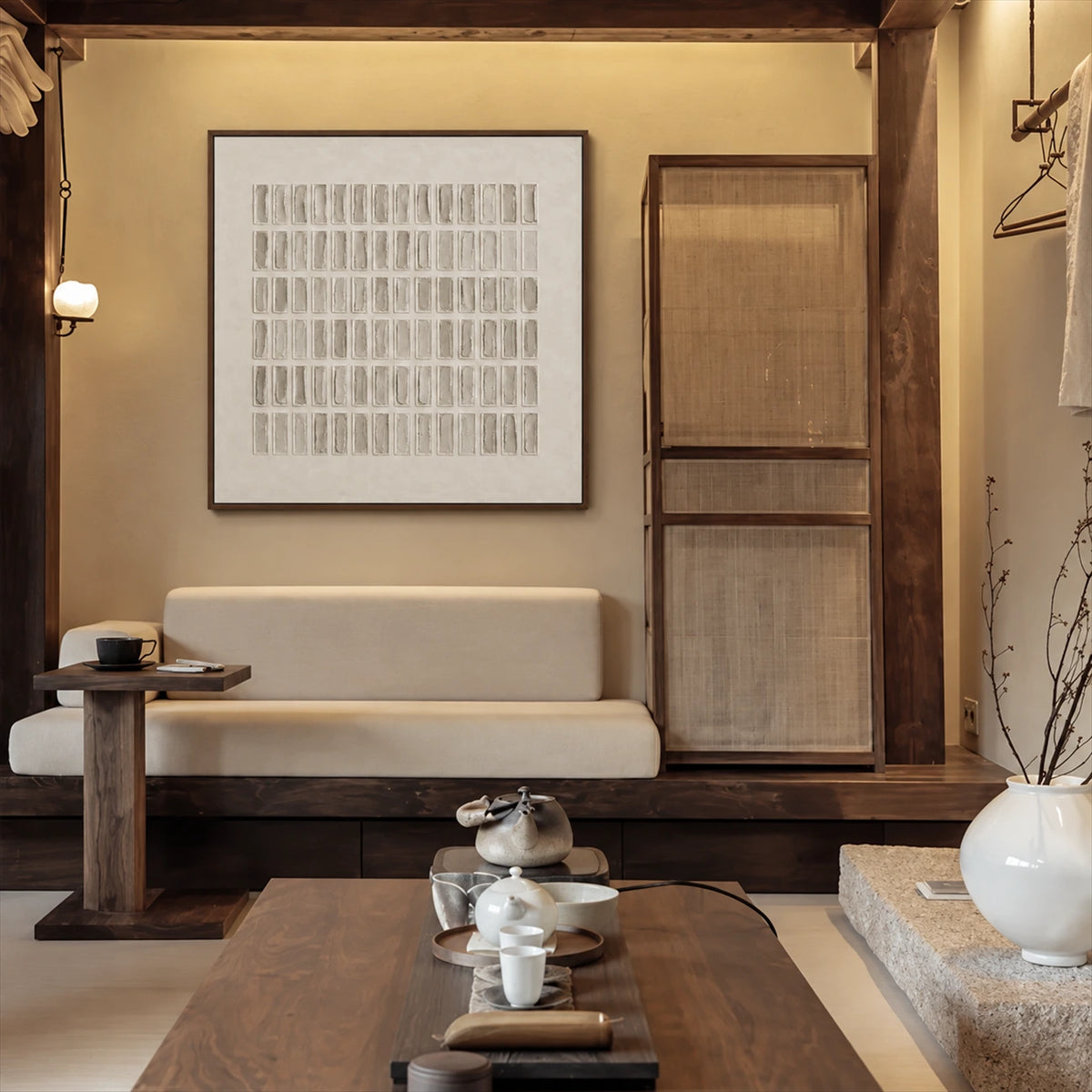 Quiet Grid painting above a low upholstered bench in a warm interior with exposed wooden beams and a tea table.