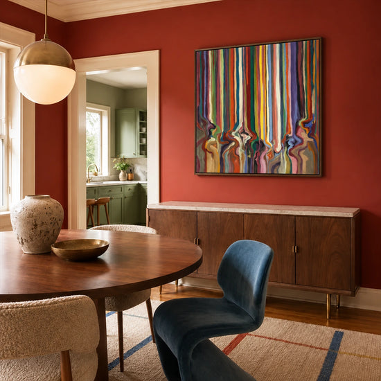 Chromatic Current painting above a wooden sideboard in a rust-red dining room.