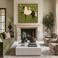 Starlit Rider painting above a fireplace beside green seating.