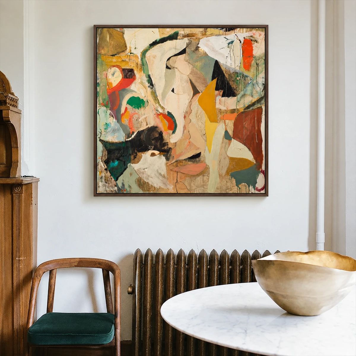Ochre Fragments painting above a dark radiator beside a round white table.