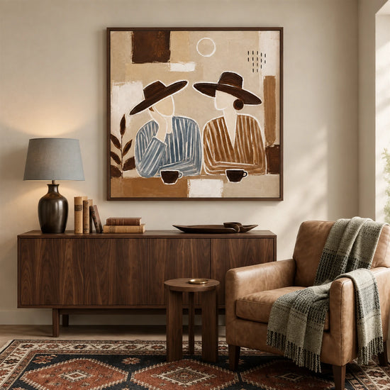 Coffee Companions painting above a wooden sideboard beside a cushioned chair and patterned rug.