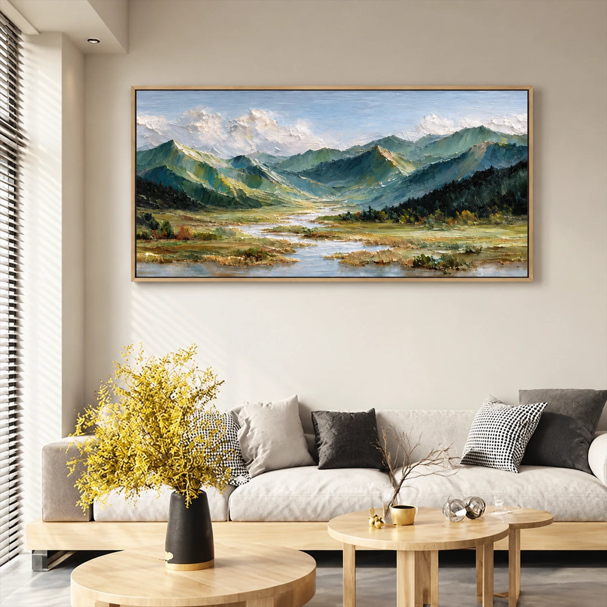 Alpine Waterways painting above a pale sofa with yellow flowers on a coffee table.