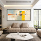 Citrine Balance painting above a taupe sectional and pale stone coffee table.