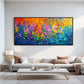 Chromatic Blossoms painting above a pale sectional and a low white coffee table.