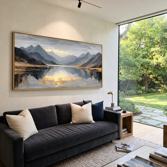 Mountain Stillness painting above a charcoal sofa beside a garden-facing window.