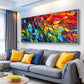 Prismatic Rhythm painting above a gray sectional beside windows.