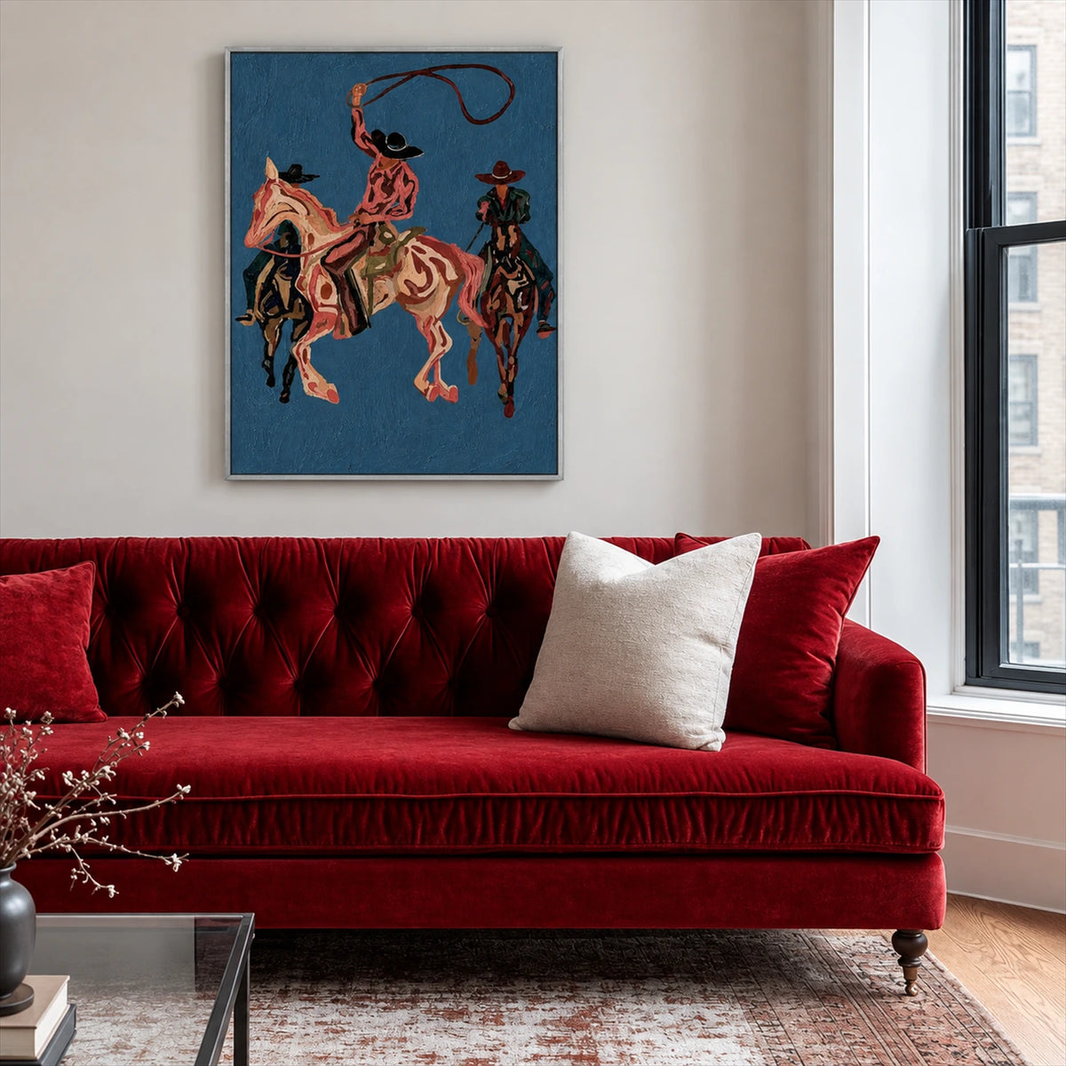 Blue Rodeo painting above a red velvet sofa beside a window.