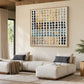 Pebble Grid artwork displayed above a pale sectional sofa in a warm wood-accented living room.