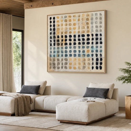 Pebble Grid artwork displayed above a pale sectional sofa in a warm wood-accented living room.